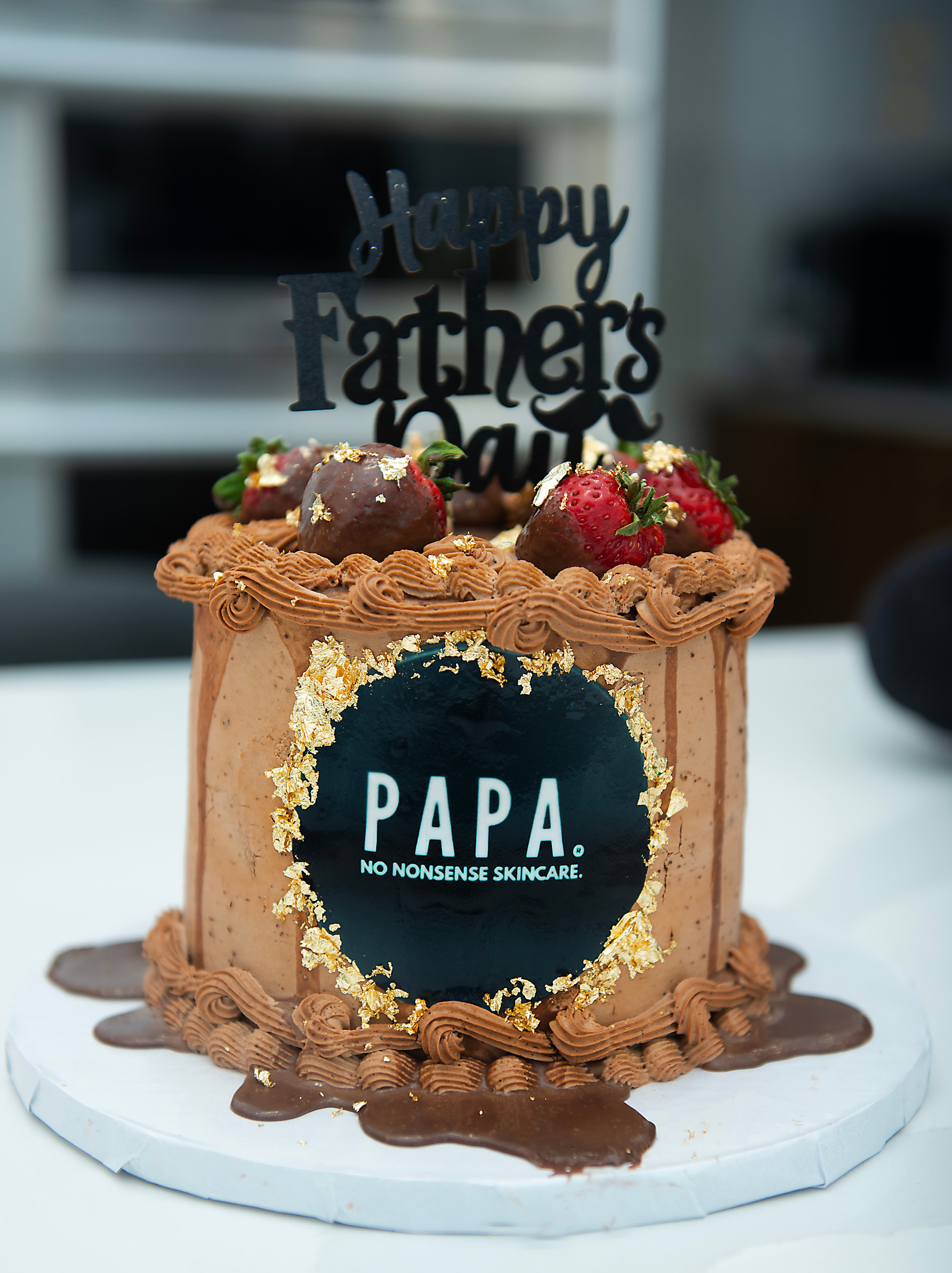 A chocolate Happy Father's Day cake topped with the PAPA logo